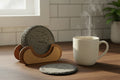 Two dragon-themed coasters with a wooden stand on a white surface.