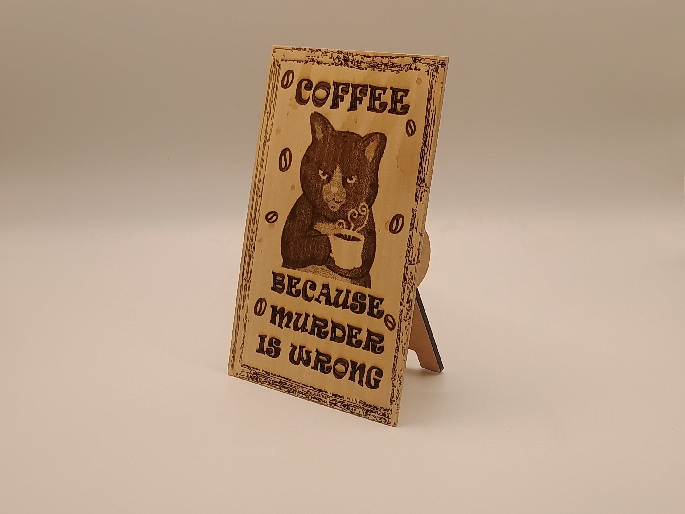 Small wooden sign with a cat holding a coffee with text