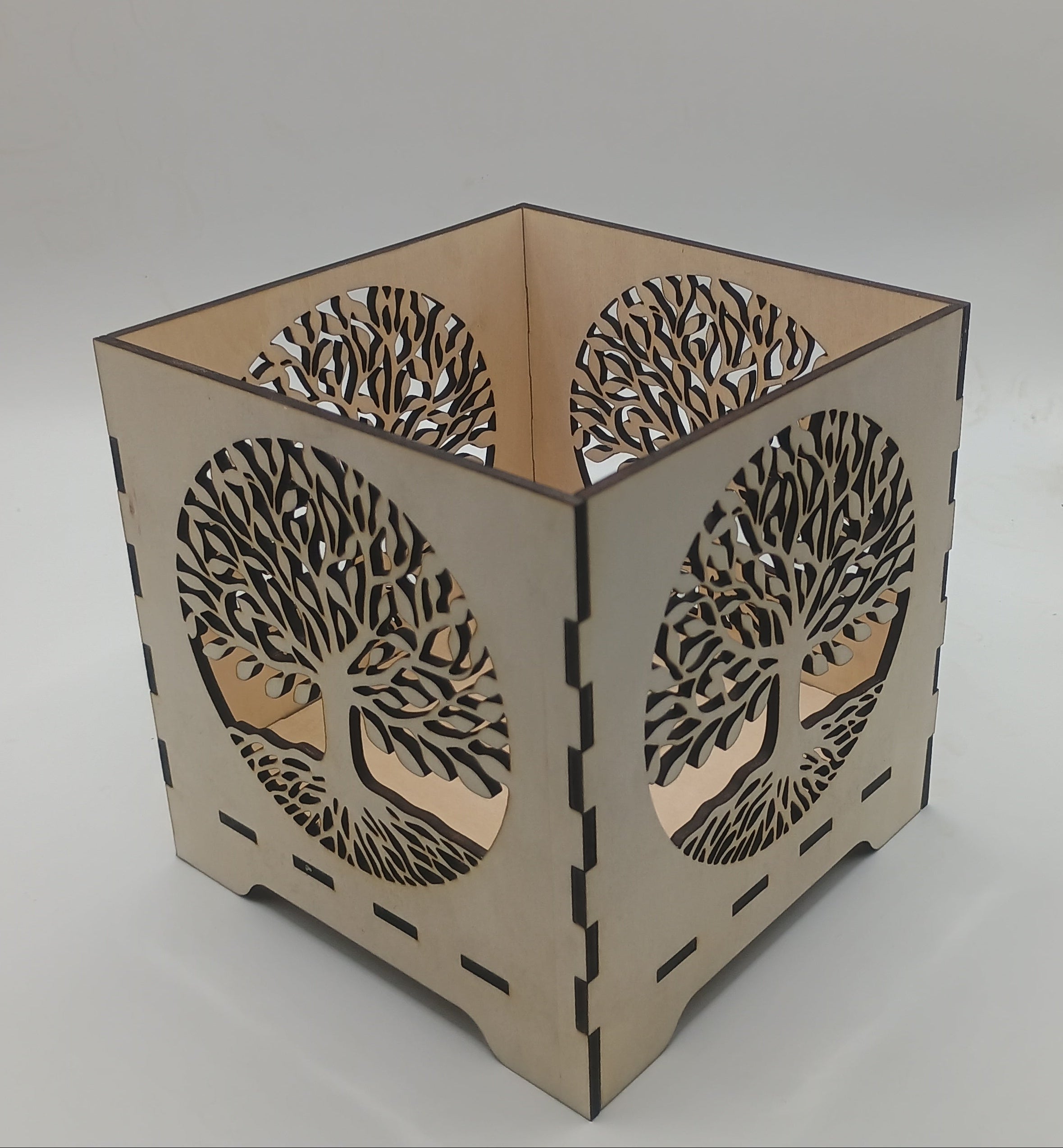 Decorative lamp with tree-of-life design on a plain background