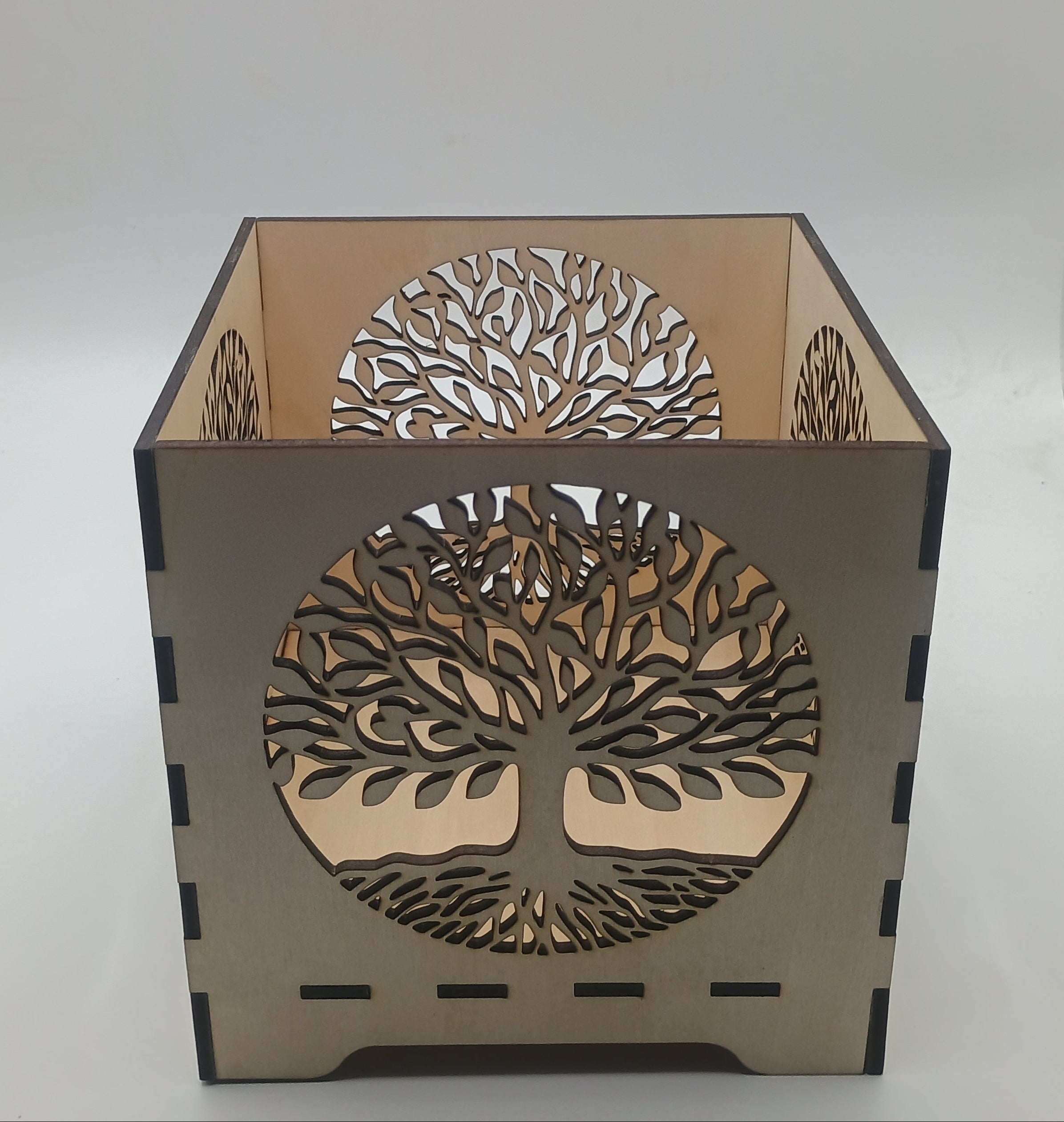 Decorative lamp with tree-of-life design on a plain background