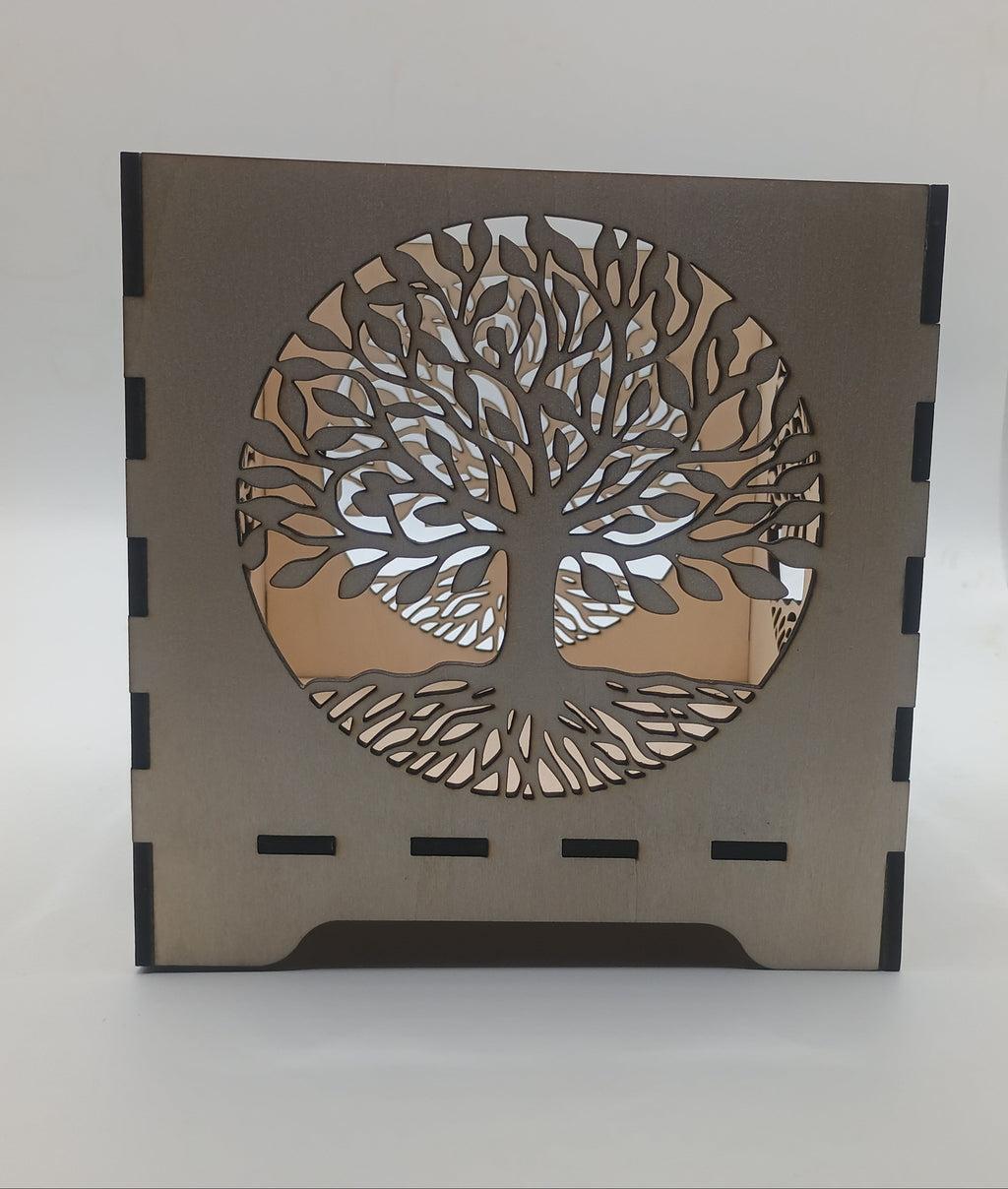 Decorative lamp with tree-of-life design on a plain background