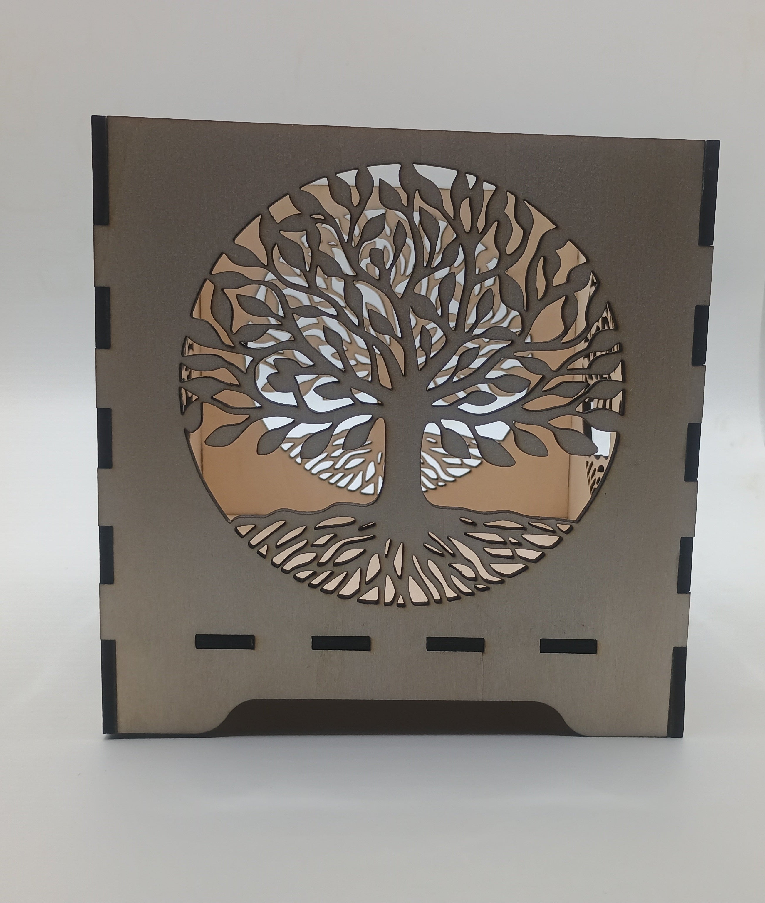 Decorative lamp with tree-of-life design on a plain background