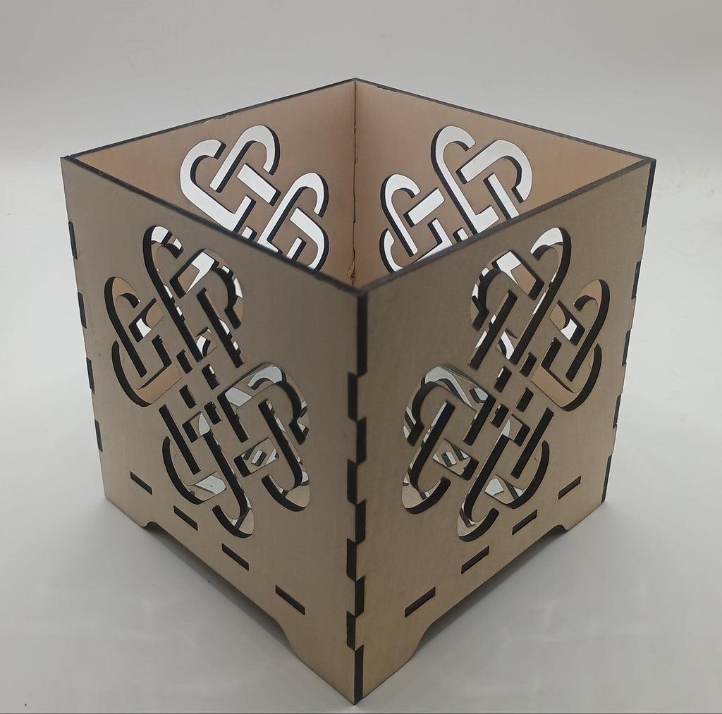 Decorative candle holder with Celtic knot design on a neutral background