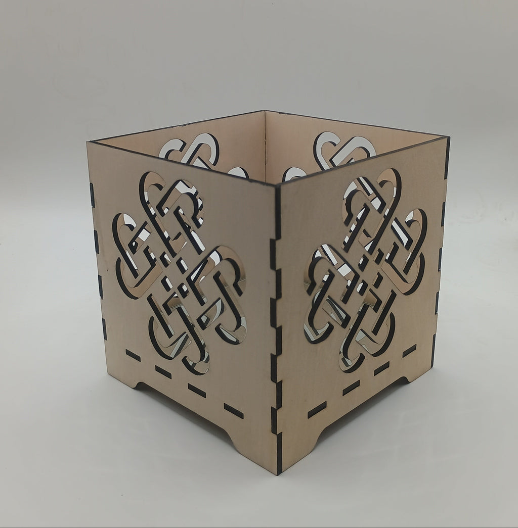 Decorative candle holder with Celtic knot design on a neutral background