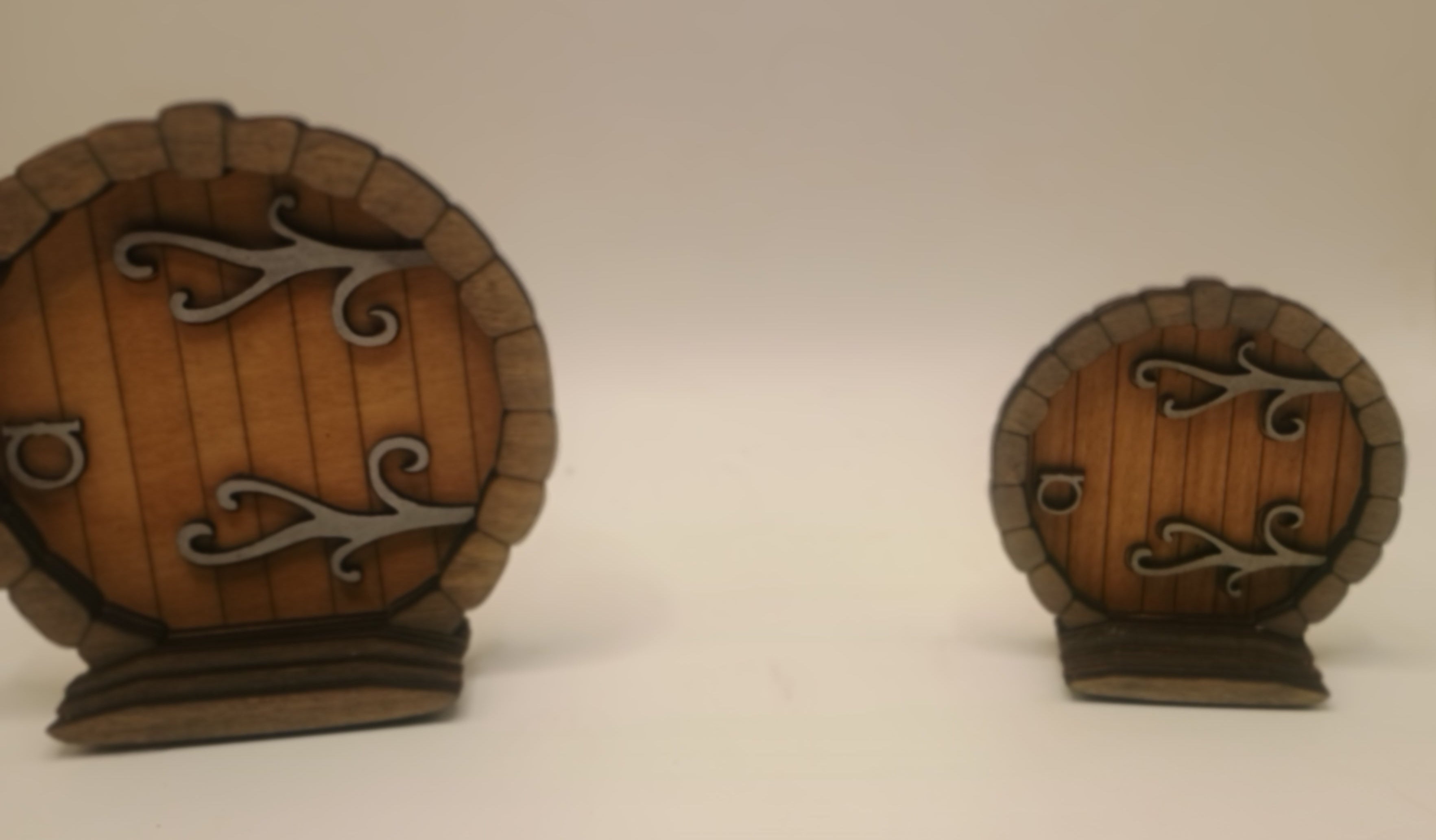 Two small wooden doors with metal hinges and handles on a white background