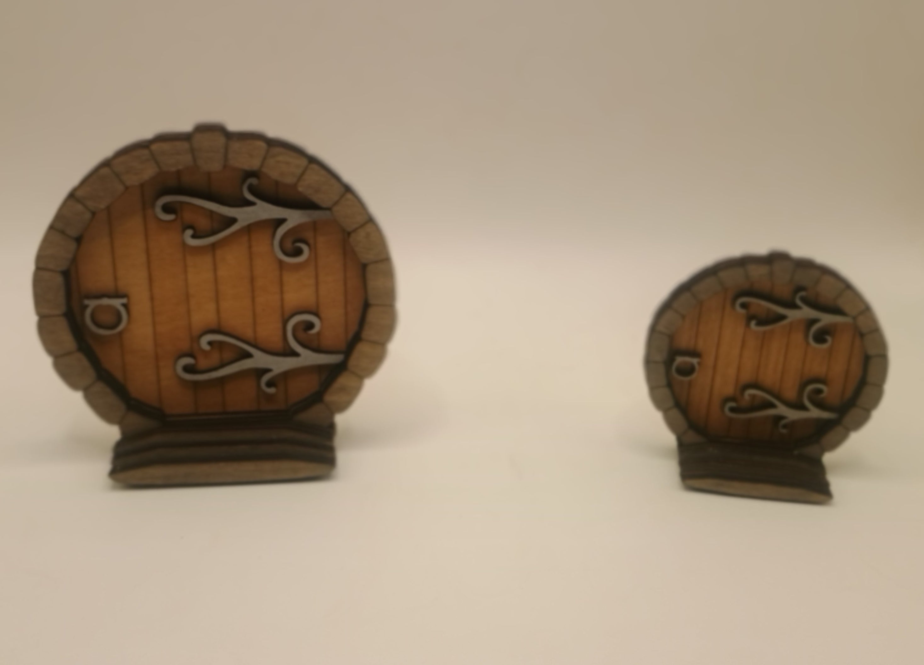 Two small wooden doors with metal hinges and handles on a white background