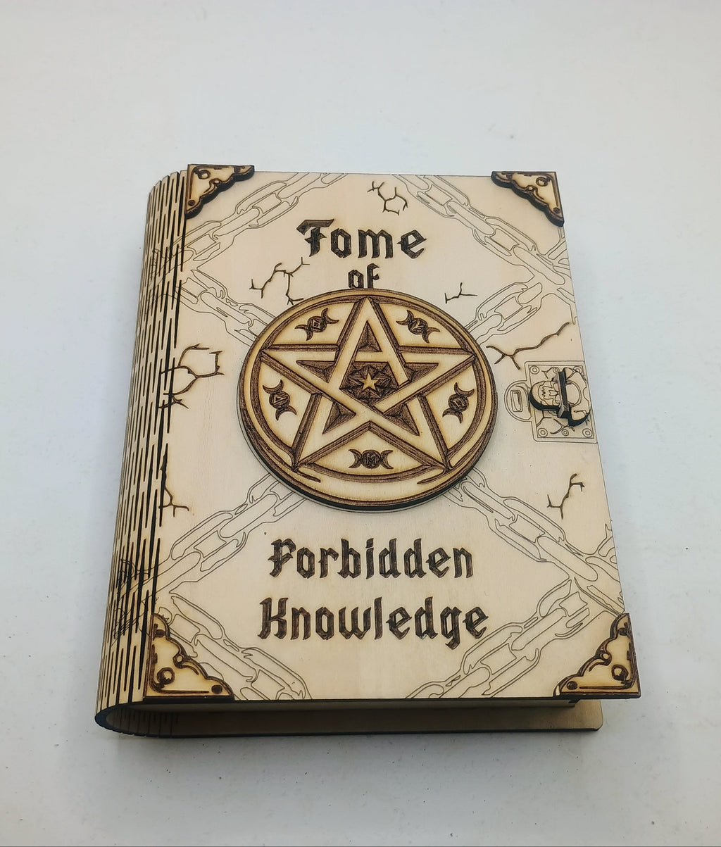 A small decorative book titled 'Fome of Forbidden Knowledge' with a large circular pentagram emblem on the cover, photographed on a plain light background.