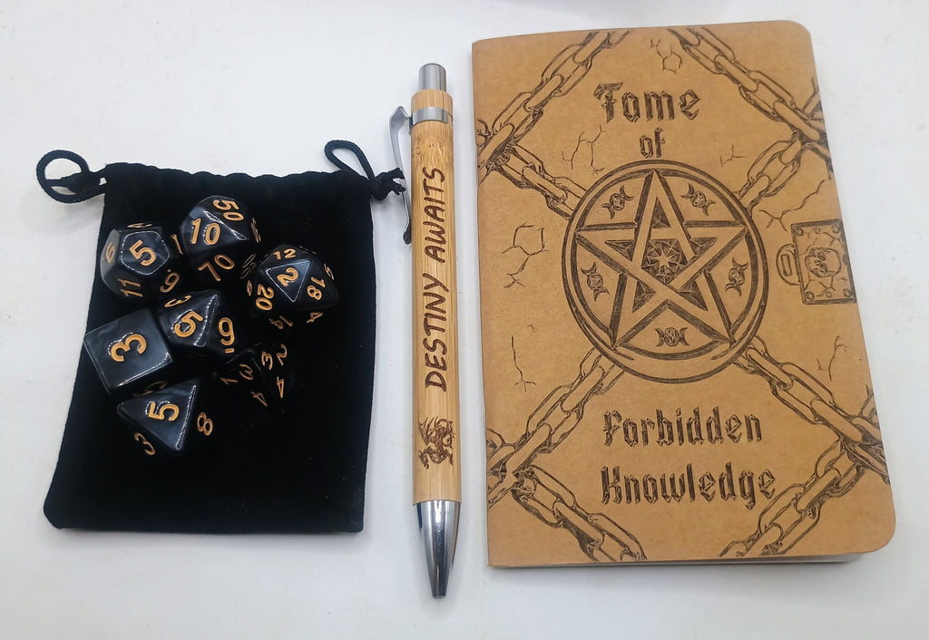 A themed tabletop set featuring a tan journal engraved with a pentagram and the words 'Tome of Forbidden Knowledge,' a black velvet pouch filled with black polyhedral dice printed in gold, and a matching engraved pen.