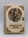 A wooden box titled 'Adventurer's Journal' featuring a carved dragon emblem on the cover