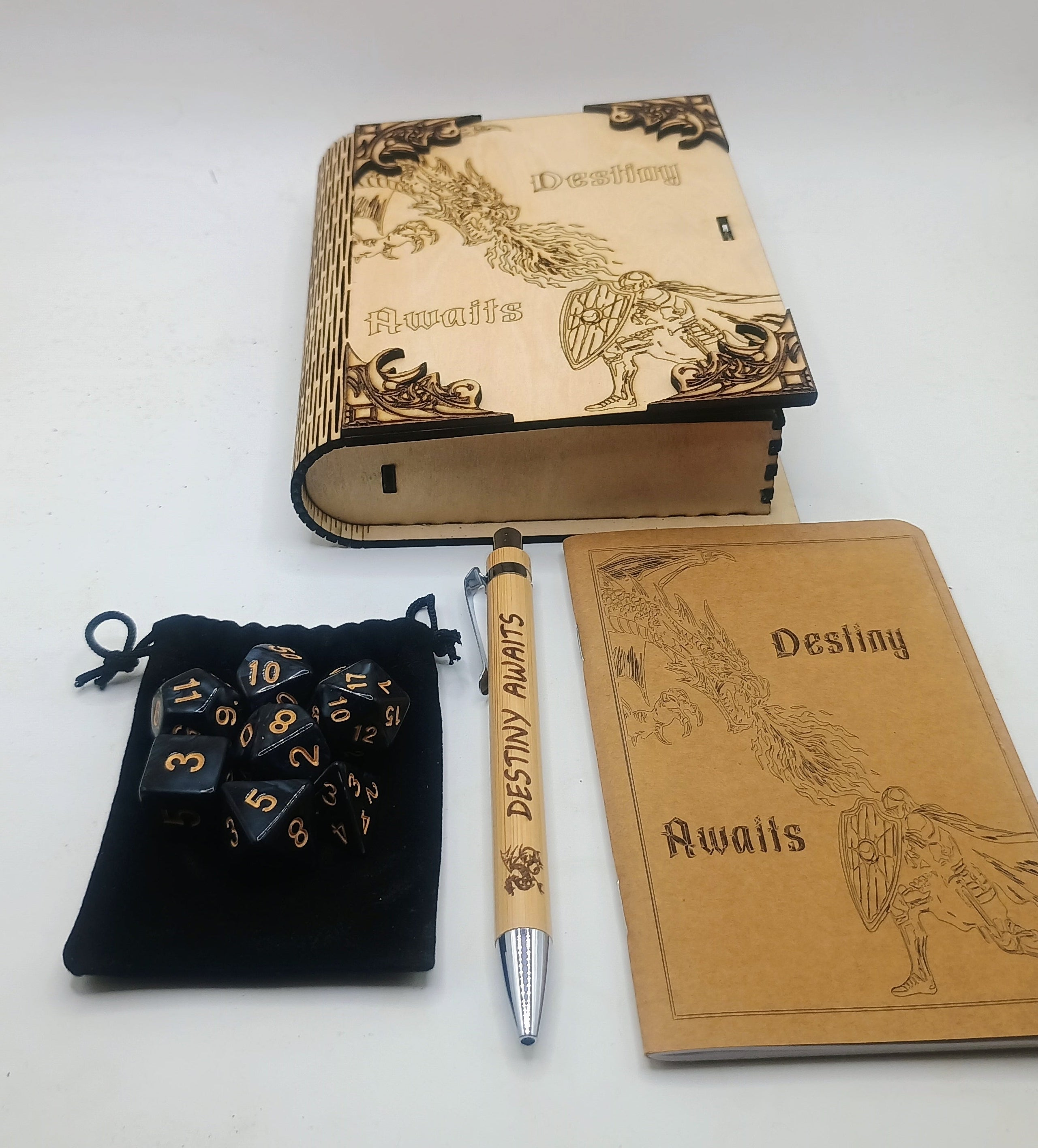 A themed gaming accessory set featuring a wooden 'Destiny Awaits' book box, a journal with a matching wooden pen, a black velvet pouch, and polyhedral dice.
